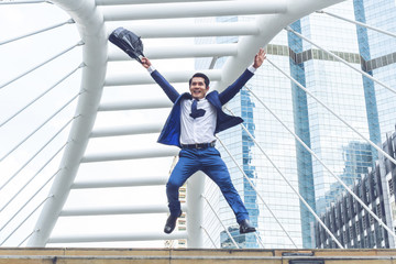 lifestyle business man feel happy jumping in air celebrating  success and achievement  on business district ,  business concept