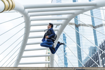 lifestyle business man feel happy jumping in air celebrating  success and achievement  on business district ,  business concept