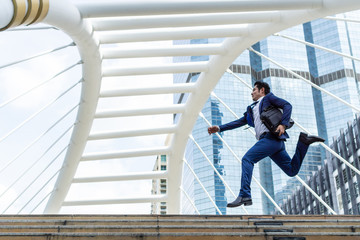 lifestyle business man feel happy jumping in air celebrating  success and achievement  on business district ,  business concept