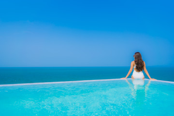 Portrait beautiful young asian woman happy smile relax in swimming pool for travel vacation