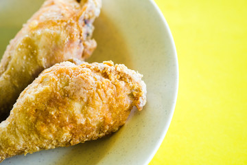 Fried Drumstick chicken shot macro on an isolated yellow background.
