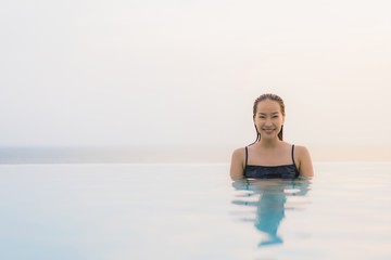 Portrait beautiful young asian woman happy smile relax around swimming pool in hotel resort