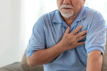 Senior male Asian suffering from bad pain in his chest heart attack at home - senior elderly people...
