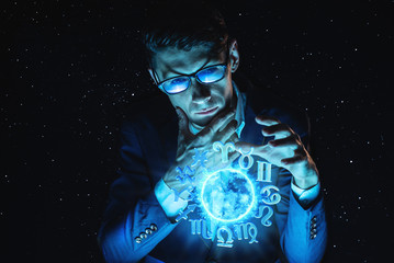 Businessman holding hands over the magic sphere with a horoscope to predict the future. Astrology as a business