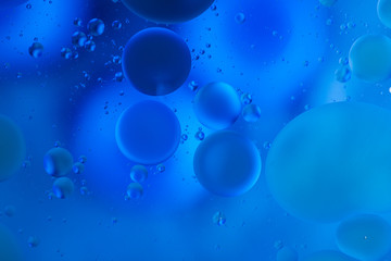 oily drops  in water with colorful background, close-up 