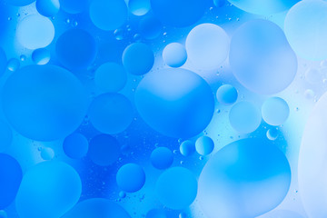 oily drops  in water with colorful background, close-up 