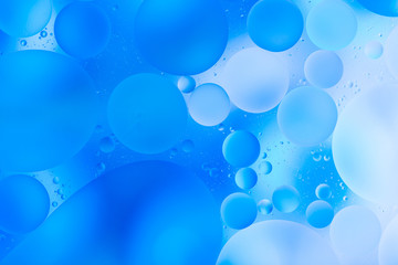 oily drops  in water with colorful background, close-up 
