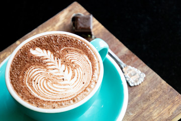 Coffee cup with latte art foam on wood table in coffee shop with copy space.Coffee is one of the most popular beverages.Improve Energy Levels and Burn Fat
