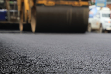Road construction asphalt road by worker and roller machine. Asphalt road background