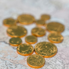 Gold coins on an old map of the world.