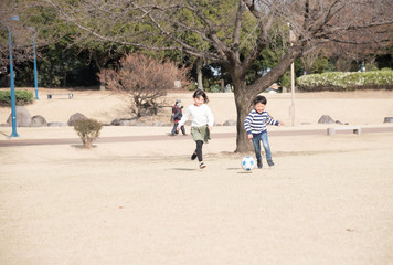 公園でサッカーをする子供