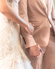 Married couple bride and groom holding hands in wedding ceremony for marriage concept