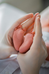 Fototapeta na wymiar Baby feet in the mother hands
