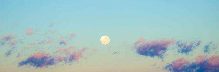 Dawn sunrise pink clouds in sky with full moon background. Beautiful skies. Sunset inspiring view and scenery.