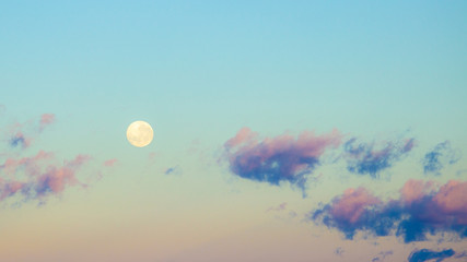 Dawn sunrise pink clouds in sky with full moon background. Beautiful skies. Sunset inspiring view...