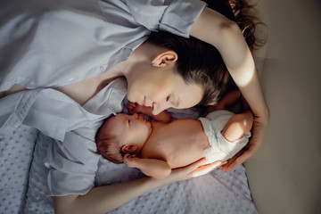 A young mother and a newborn boy are lying nearby. Mothers Day