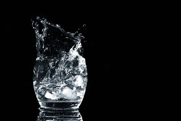 glass of water with splash isolated on black background