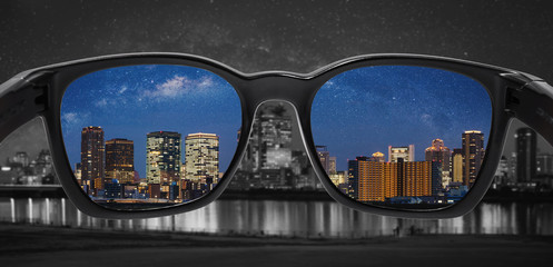 Looking through glasses to city at night. Color blindness glasses, Smart glass technology	