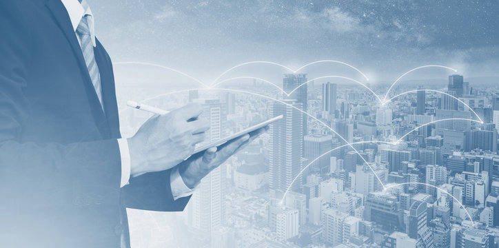 Business network, blockchain technology and internet connection. Businessman working on digital tablet, and city networking