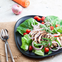 Organic vegetables salad with grilled chicken on black plate. Healthy food. Beauty concept