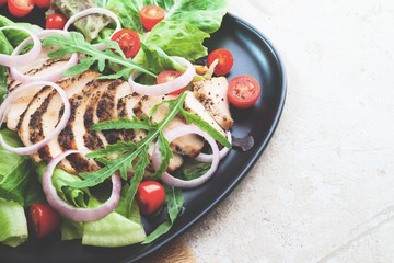 Close up healthy salad with grilled chicken, onions and tomatoes. Healthy food.