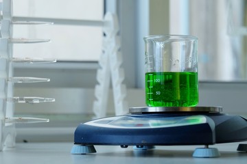 Scientists are drops of solution into a beaker containing chemicals scales with Digital weighing scales. - Image