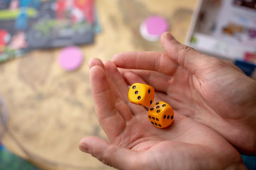 Hands throws yellow dice on the game field. Luck and excitement. Concept of Board games. Gaming moments in dynamics