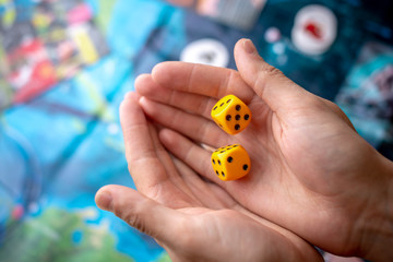 Hands throws yellow dice on the game field. Luck and excitement. Concept of Board games. Gaming...