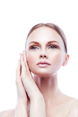 Beauty woman model touching clean face skin with hands. Blond hair, natural nude make-up. Isolated. White background. Copy space