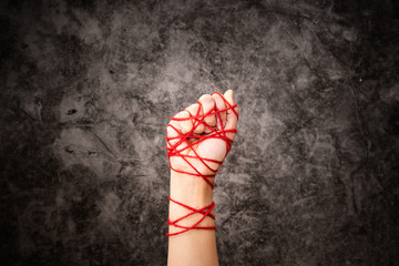 Women hand tied with rope, the idea of freedom expression on dark grunge background in low key....