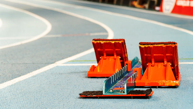 Athletics starting blocks on race blue track