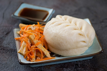 Steamed korean pjan-se bun with salad over grey stone background, studio shot
