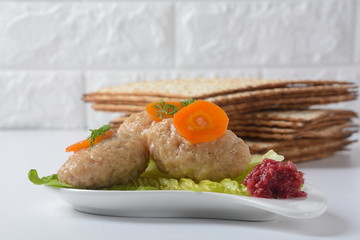 Passover Pesach traditional Jewish food - gefilte fish with, lettuce, carrots, horse radish and matzah. Passover celebration concept