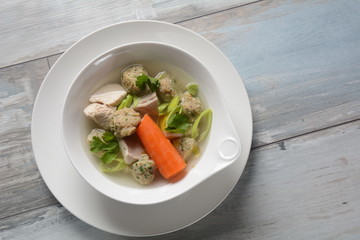 Chicken soup with Matzah balls (Kneidlach) carrots in the bowl. Jewish traditional Passover Pesach holiday food