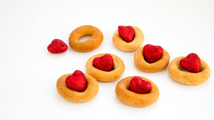 Creative image. Love and friendship. Loneliness, misunderstanding.The concept of Valentine Day. Bread rings on a white background in combination with red hearts.