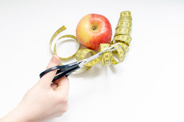 healthy food concept with an Apple and a pair of scissors and elastic meter