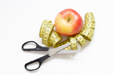 healthy food concept with an Apple and a pair of scissors and elastic meter