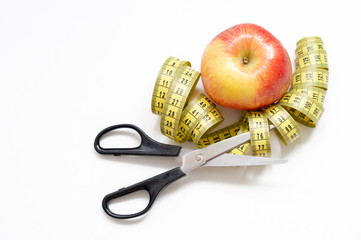 healthy food concept with an Apple and a pair of scissors and elastic meter