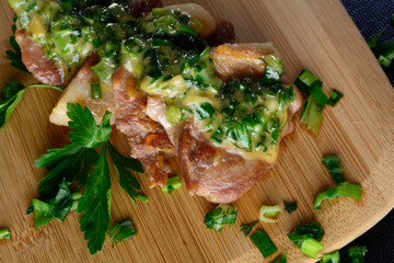 Meat on a wooden board with onions. Delicious food