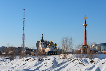 Fototapeta na wymiar A winter or spring view on historical district of the Yakutsk city, Yakutia - the Old Town, a Christian Church and monument to the founder of the city, Petr Beketov