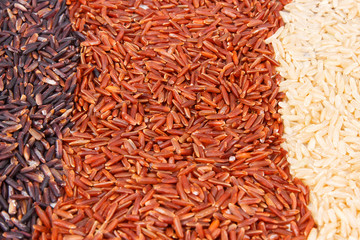 Heap of brown, red and black rice as background, healthy nutrition concept