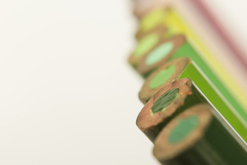 various tones of green color pencils Close up on white background