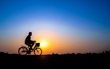 Naklejka na ściany i meble cyclist on sunset background