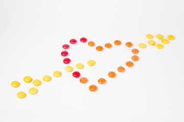 Shape of heart pierced with arrow - I love you - made from colorful sweet candies.
