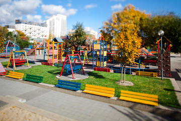 Fototapeta na wymiar Colorful playground without children during summer time - Tilt shift lens