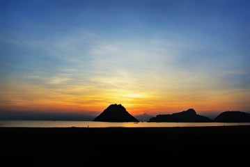 Fototapeta na wymiar The most romantic sunrise.Silhouette sea mountains and sun