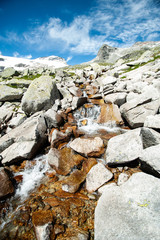 wild stream infront of mountains and  blue sky