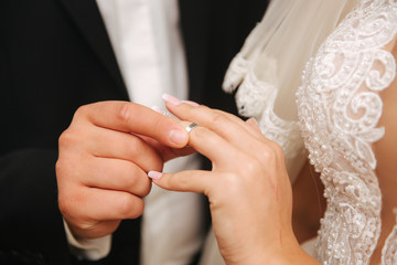 Close up of hands groom and bride wearing a ring
