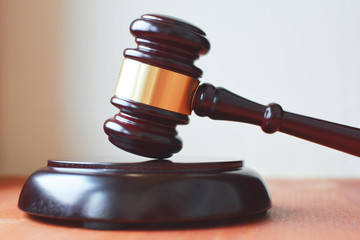 Obraz premium Judges gavel or law mallet and sound block wooden background, close-up. Judgement or auction, justice and judgements concept.