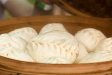 Fototapeta na wymiar Steamed Korean dumplings Mandu with chicken meat and vegetables in a bamboo steamer
